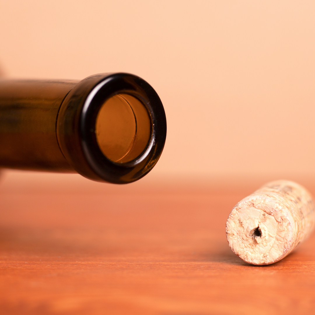 Wine cork and lying empty  bottle  on the table.